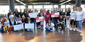 Mitglieder von Inner Wheel und Soroptimist sowie Menschen aus der Johannes-Diakonie posieren bei einerSpendenübergabe im Kultur- und Begegnungszentrum fideljo.